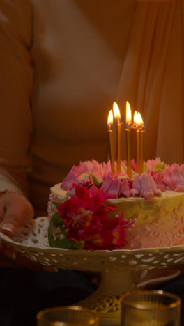 Vertical-Video-Close-Up-Of-Woman-Wearing-Hijab-Holding-Birthday-Cake-Decorated-With-Lit-Candles-At-Party-At-Home